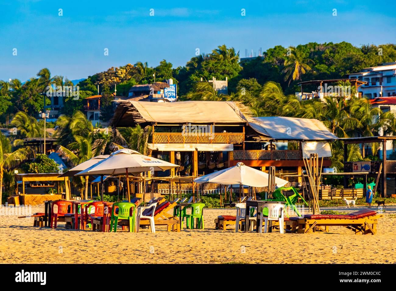 Puerto Escondido Oaxaca Mexique 16. Novembre 2022 Palm Trees personnes parasols parasols parasols et chaises longues au Beach Resort Hotel sur Tropical Mexican B Banque D'Images