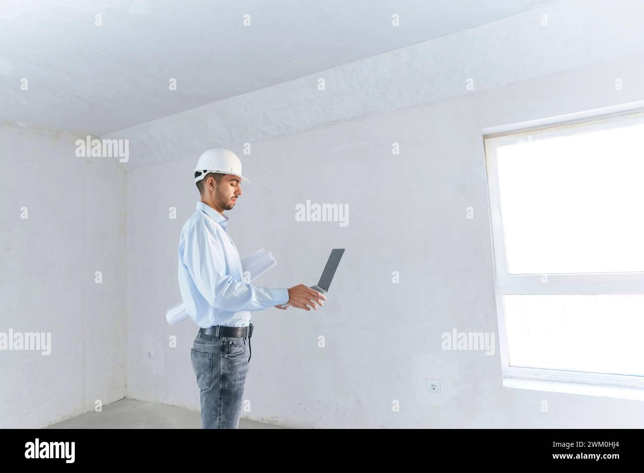 Jeune architecte travaillant sur ordinateur portable sur le chantier de construction Banque D'Images