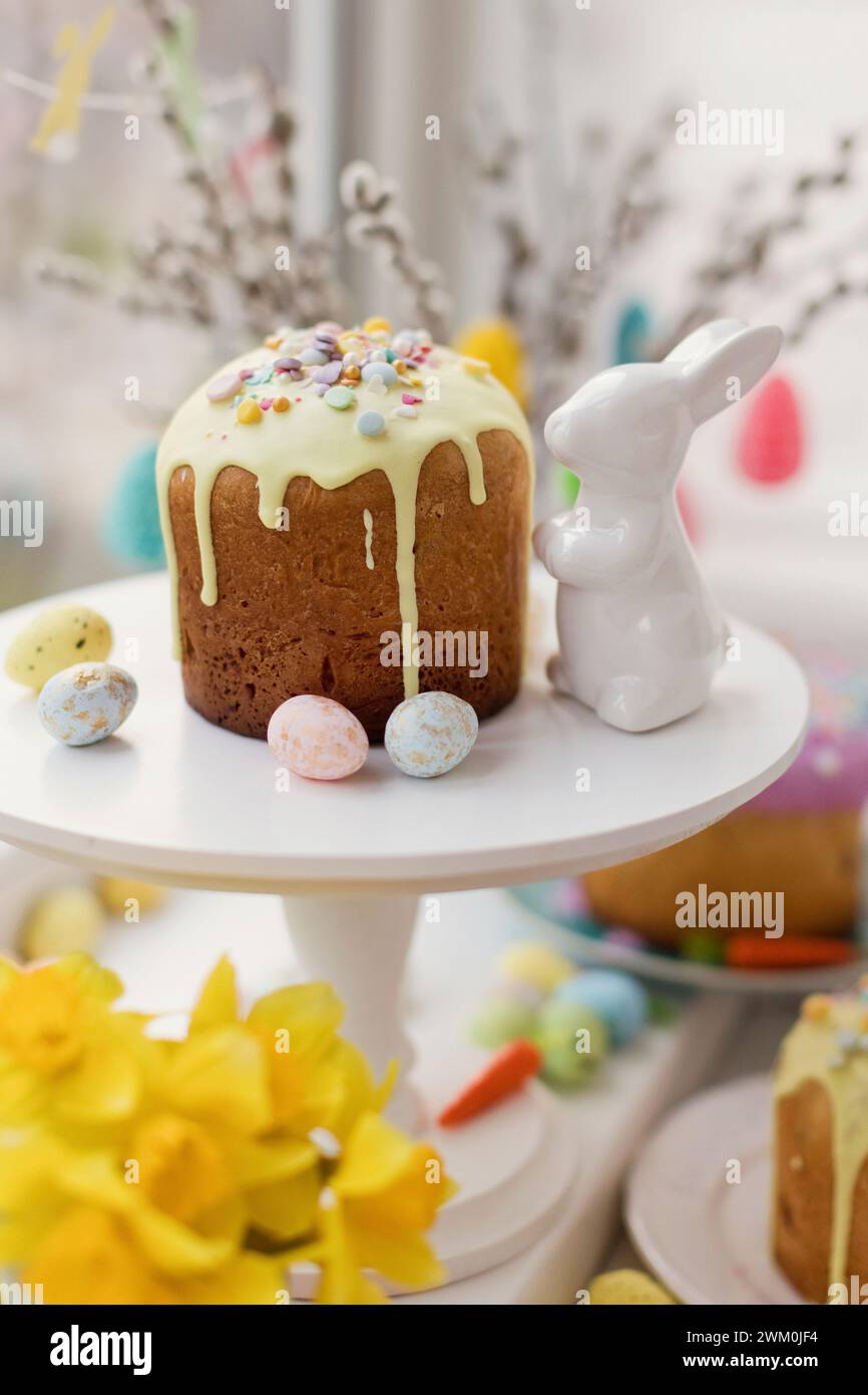 Gâteau décoré avec des saupoudrons de sucre près du lapin de Pâques jouet Banque D'Images