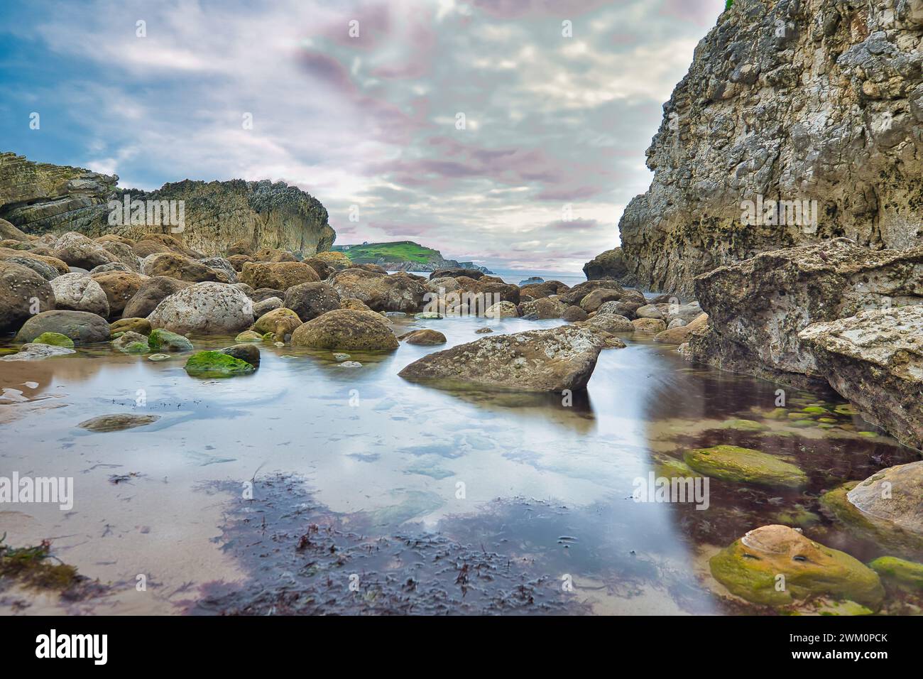 Plage rocheuse avec de l'eau sous le ciel couvert Banque D'Images