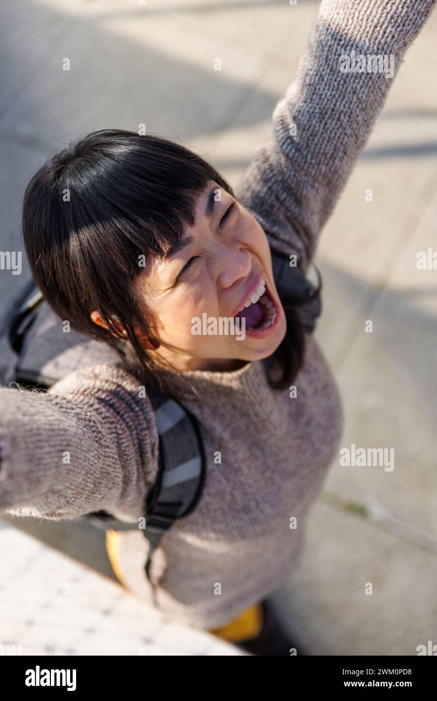 Femme joyeuse debout avec les bras levés sur le sentier Banque D'Images