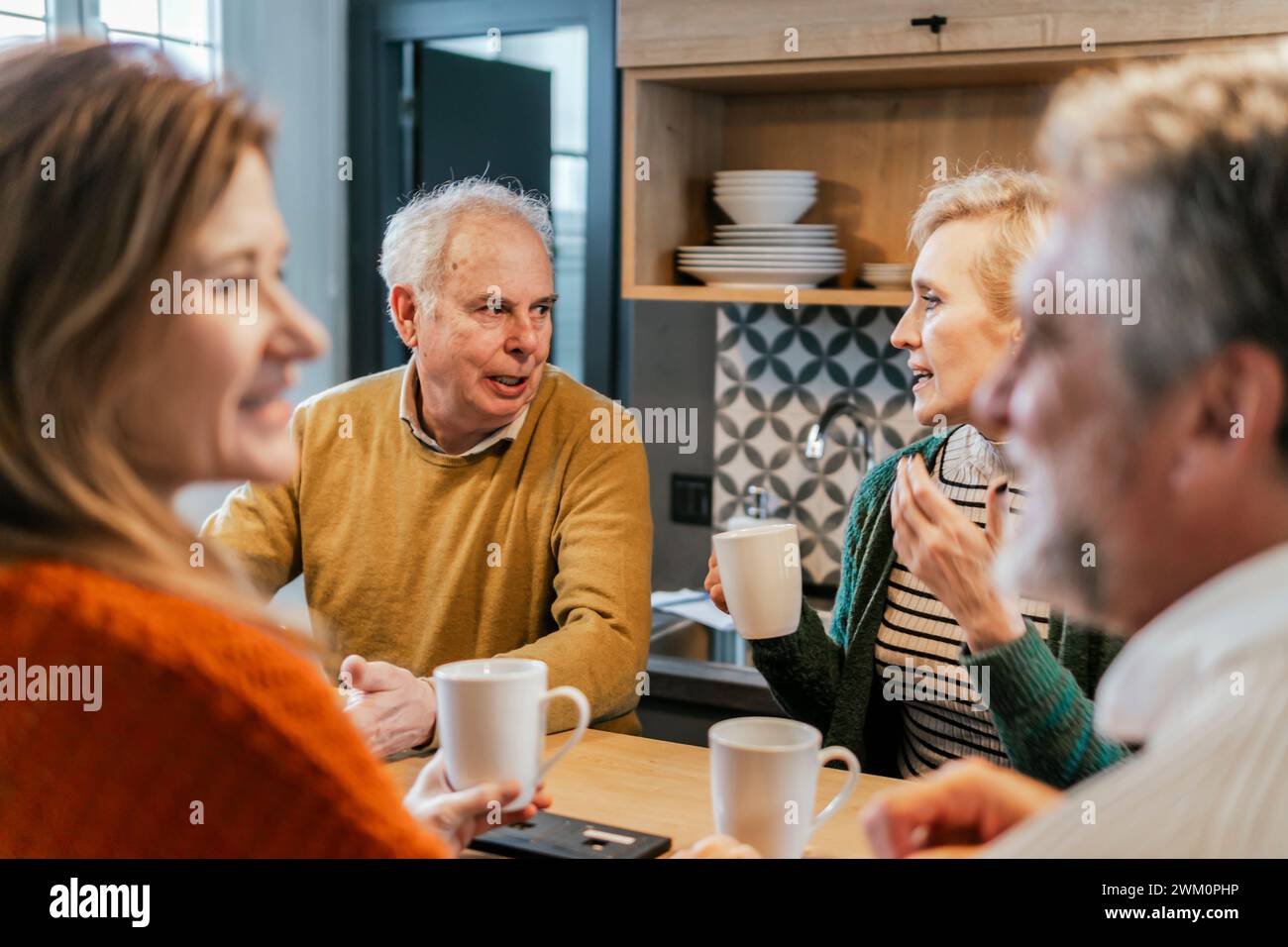 Des amis se parlent à table Banque D'Images