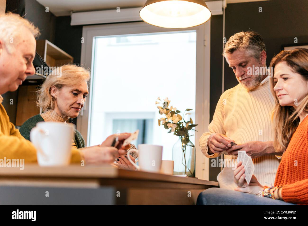 Amis jouant aux cartes ensemble à table Banque D'Images
