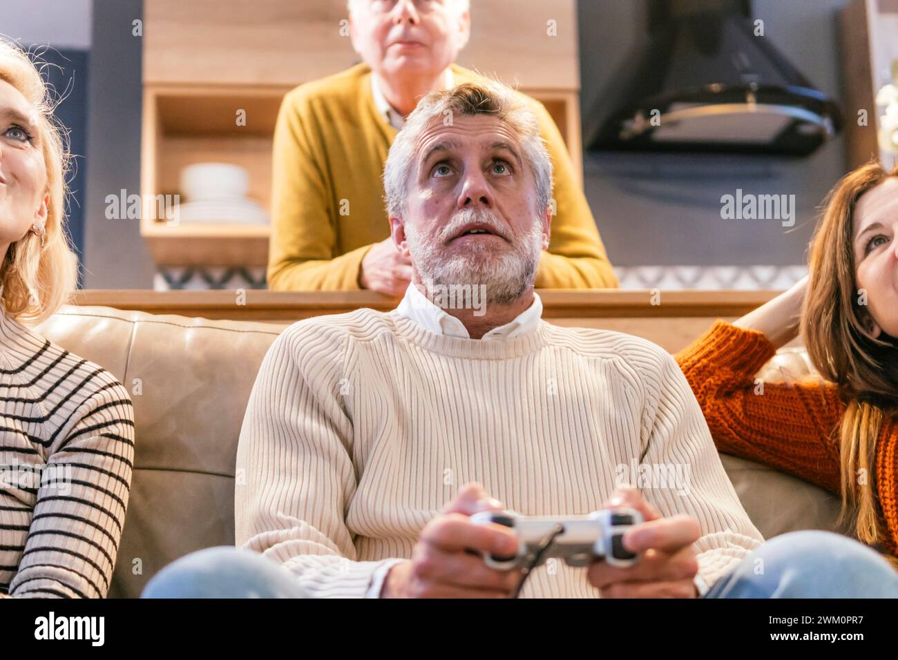 Amis avec homme jouant au jeu vidéo à la maison Banque D'Images