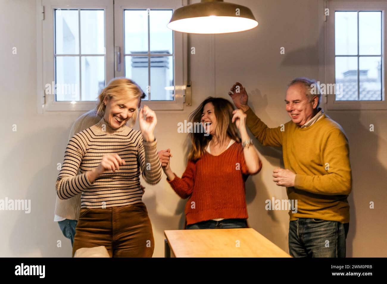 Heureux amis dansant et appréciant à la maison Banque D'Images