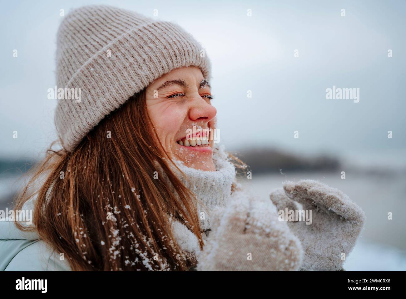 Femme heureuse riant les yeux fermés en hiver Banque D'Images