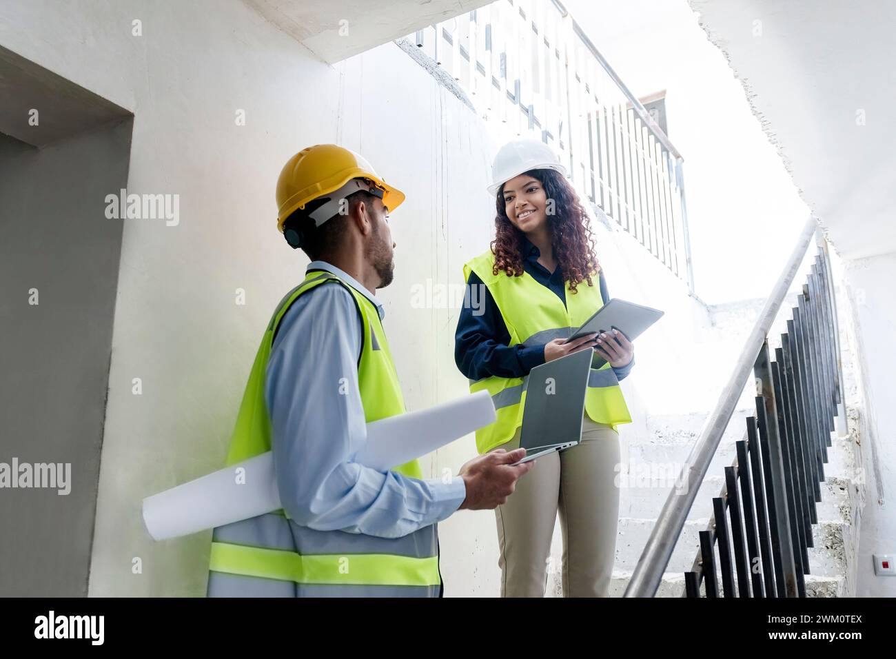 Architectes souriants discutant sur les marches sur le site Banque D'Images