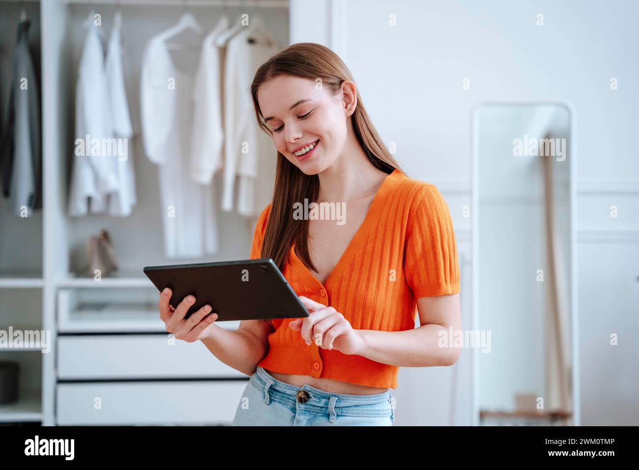 Jeune femme souriante utilisant une tablette PC à la maison Banque D'Images