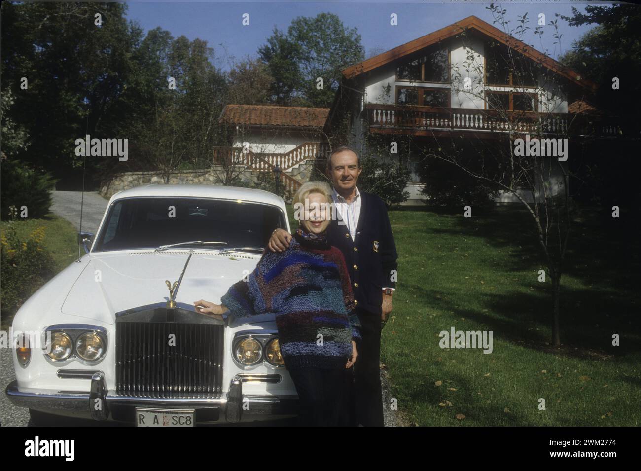 MME4791336 Comté de Westchester, État de New York, 1989. La soprano italienne Renata Scotto et son mari Lorenzo Anselmi appuyés sur leur Rolls Royce avec plaque d'immatriculation personnalisée, garés devant leur maison/comté de Westchester, État de New York, 1989. Il soprano Renata Scotto e suo marito Lorenzo Anselmi appoggiati alla loro Rolls-Royce con targa personalizzata, parcheggiata di fronte alla loro casa - ; (add.info.: comté de Westchester, État de New York, 1989. La soprano italienne Renata Scotto et son mari Lorenzo Anselmi s’appuyant sur leur Rolls Royce avec plaque d’immatriculation personnalisée, garée en fr Banque D'Images