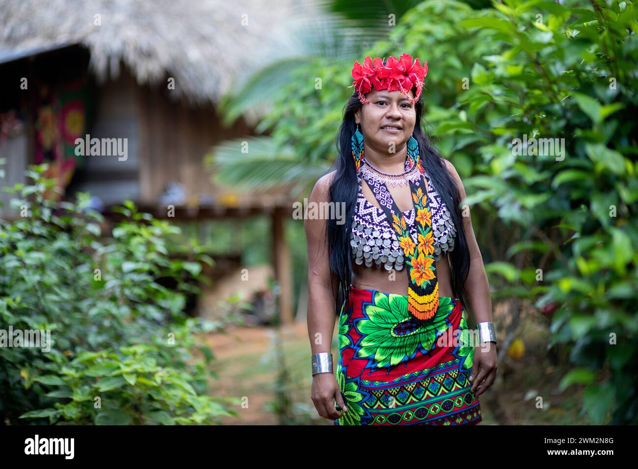Femme indigène Embera avec une peinture faciale traditionnelle frappante et des fleurs dans les cheveux, dans un petit village entouré de forêt tropicale au Panama. Banque D'Images