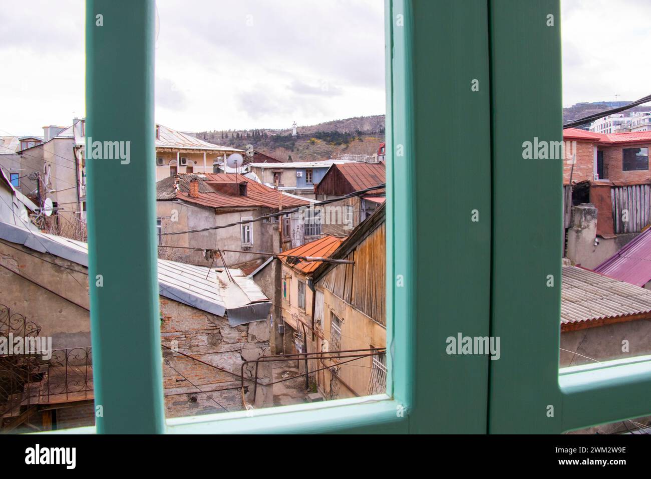 Paysage urbain vu à travers une fenêtre ouverte avec une clôture Banque D'Images