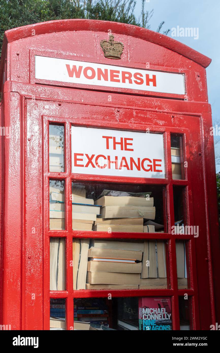 Vieille boîte de téléphone rouge dans le village de Wonersh étant utilisé comme un échange pour des livres et des puzzles, Surrey, Angleterre, Royaume-Uni Banque D'Images