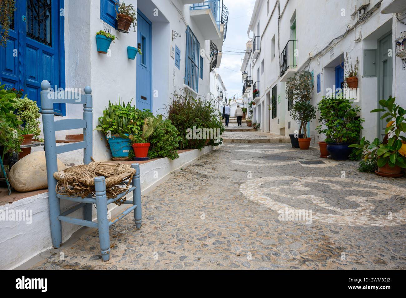 Une vieille chaise bleue dans la rue du merveilleux village de Frigiliana avec des maisons blanches avec des portes et des fenêtres bleues, Malaga, Andalousie, Espagne Banque D'Images