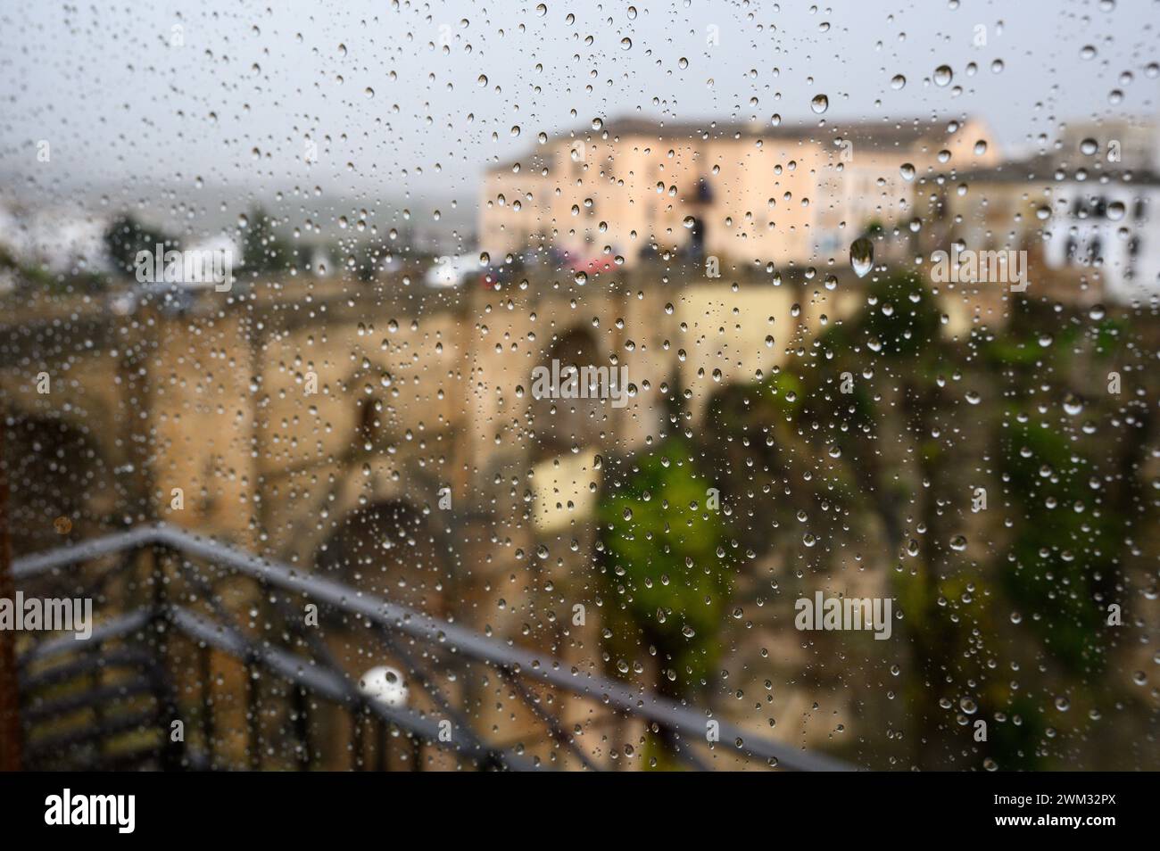 Vue sur le pont Nuevo de Ronda depuis la fenêtre de l'hôtel avec des gouttes de pluie sur le verre, Malaga, Andalousie, Espagne. Banque D'Images