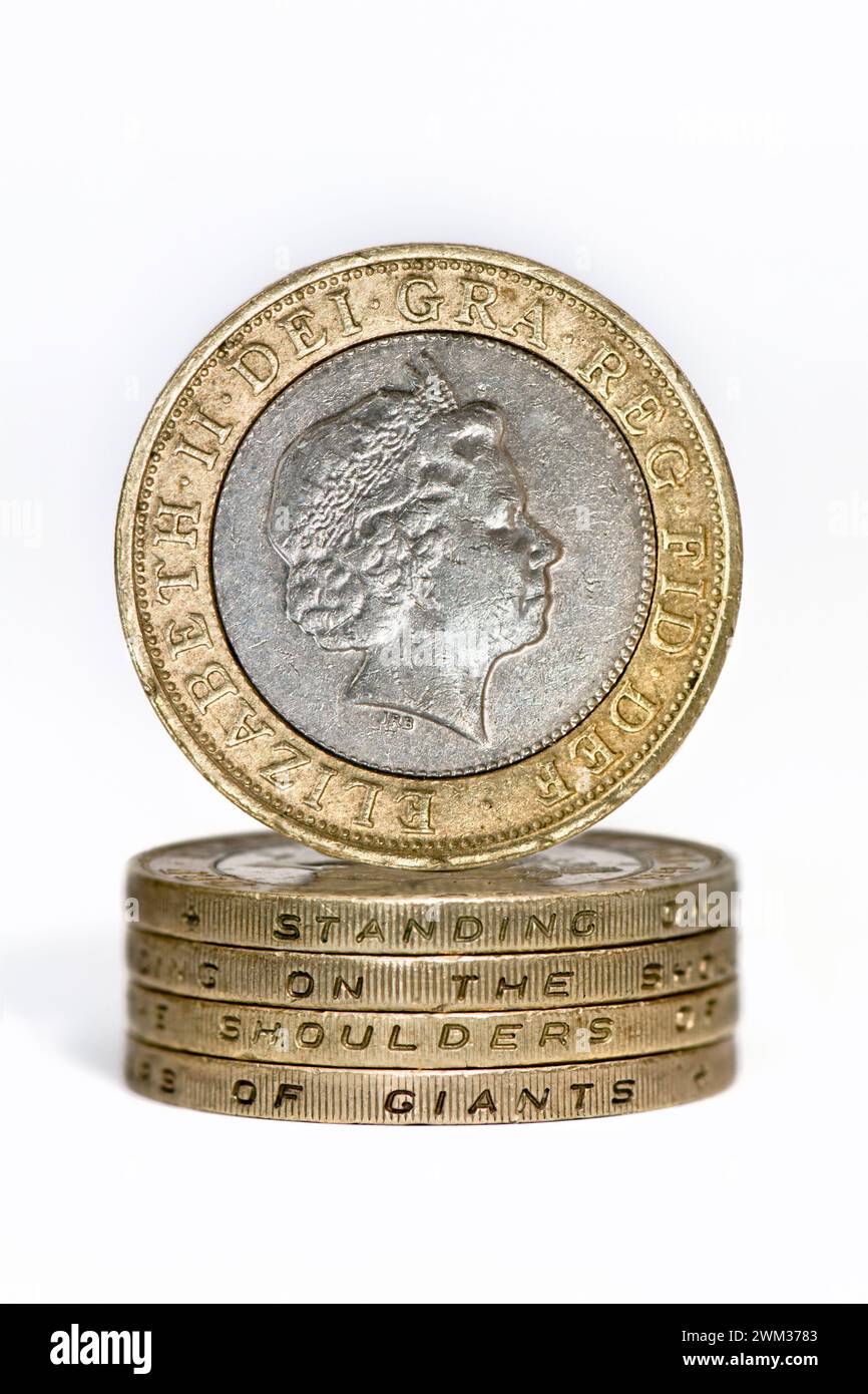 Plan de studio de pièces de deux livres sterling en pile en écrivant « debout sur les épaules des géants » avec une pièce de deux livres verticale équilibrée sur le dessus de l'agai Banque D'Images