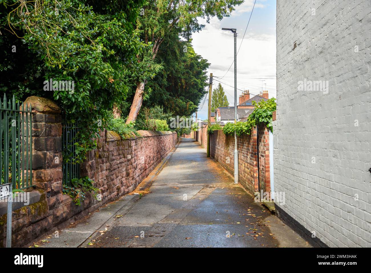 Rue étroite vide courant entre des murs de pierre et de briques par une journée d'été ensoleillée Banque D'Images