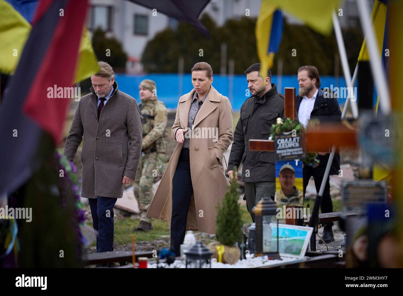 Lviv, Ukraine. 23 février 2024. Le président ukrainien Volodymyr Zelenskyy, à droite, marche avec le premier ministre danois mette Frederiksen, au centre, et son mari Bo Tengberg alors qu’ils rendent hommage aux soldats tombés au champ de mars à l’intérieur du cimetière de Lychakiv, le 23 février 2024 à Lviv, en Ukraine. Crédit : Pool photo/Bureau de presse présidentiel ukrainien/Alamy Live News Banque D'Images