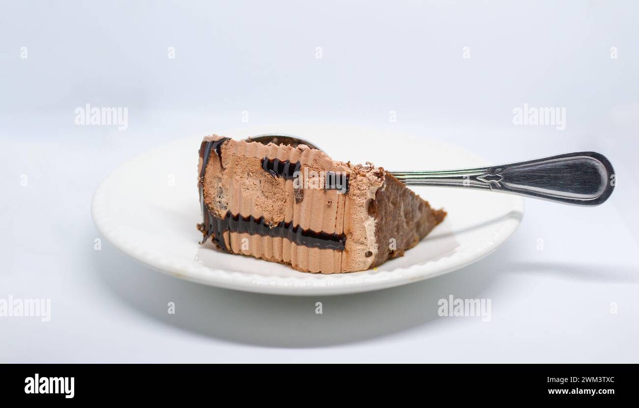 petit morceau de gâteau au chocolat, goût délicieux, couleur brune sur fond blanc Banque D'Images