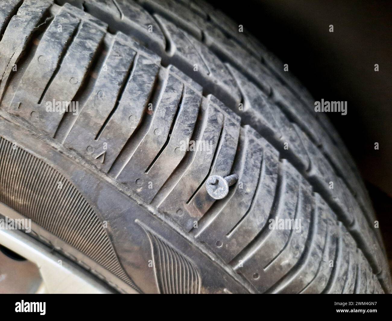 vieille vis rouillée ou clou à l'intérieur d'un pneu de voiture qui a causé un dommage et le pneu doit être réparé ou remplacé, concept de service de mécanicien de voiture, pointe de pneu esprit Banque D'Images