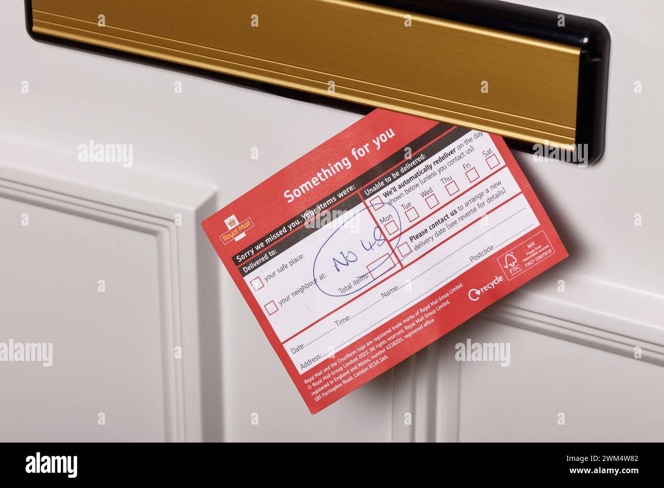 Un Royal mail quelque chose pour vous a manqué la carte de livraison dans une boîte aux lettres Banque D'Images