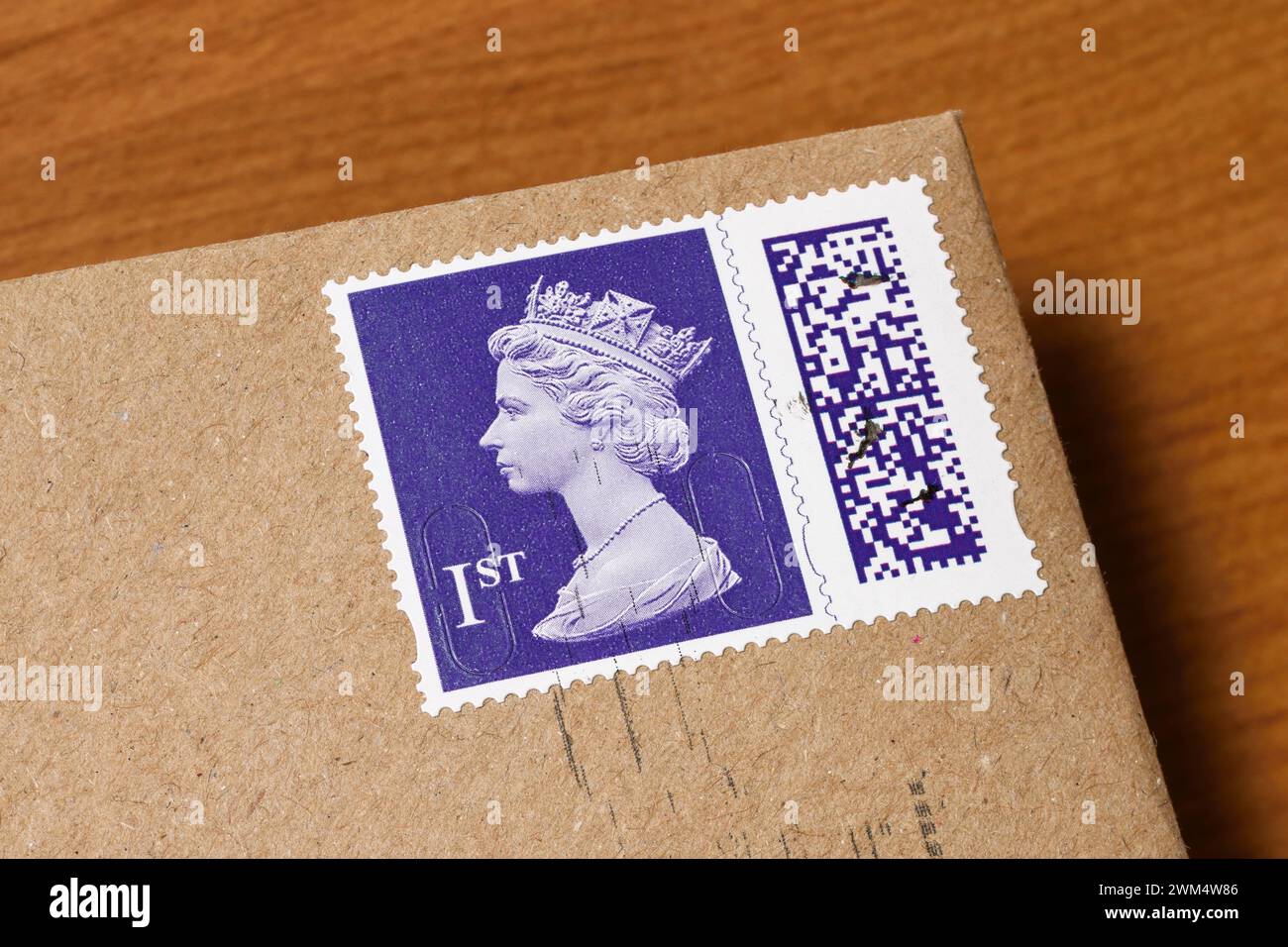 Un timbre de première classe à code-barres Royal mail sur une enveloppe marron Banque D'Images
