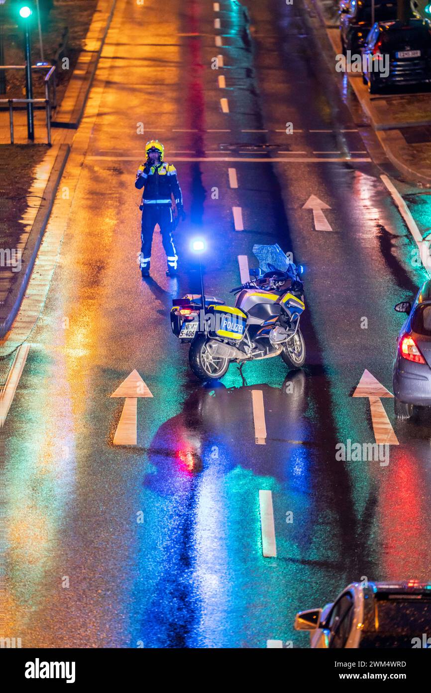 Policier avec moto, par temps pluvieux, bloquant une route, moto de police avec lumière bleue, Banque D'Images