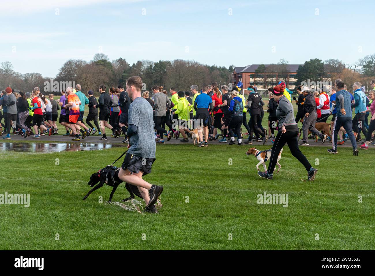 Les personnes participant à Rushmoor Parkrun, un événement de course régulier le samedi à Aldershot, Hampshire, Angleterre, Royaume-Uni, en février 2024 Banque D'Images