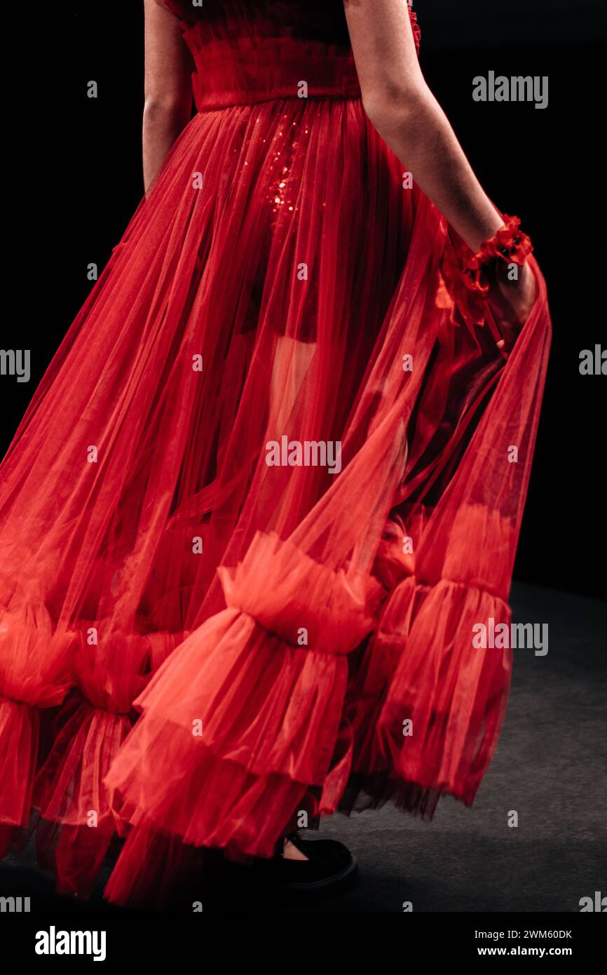 Détails d'une robe de soirée en organza rouge luxuriant sur une figure féminine sur un fond noir. Vêtements de mode élégants et féminins Banque D'Images