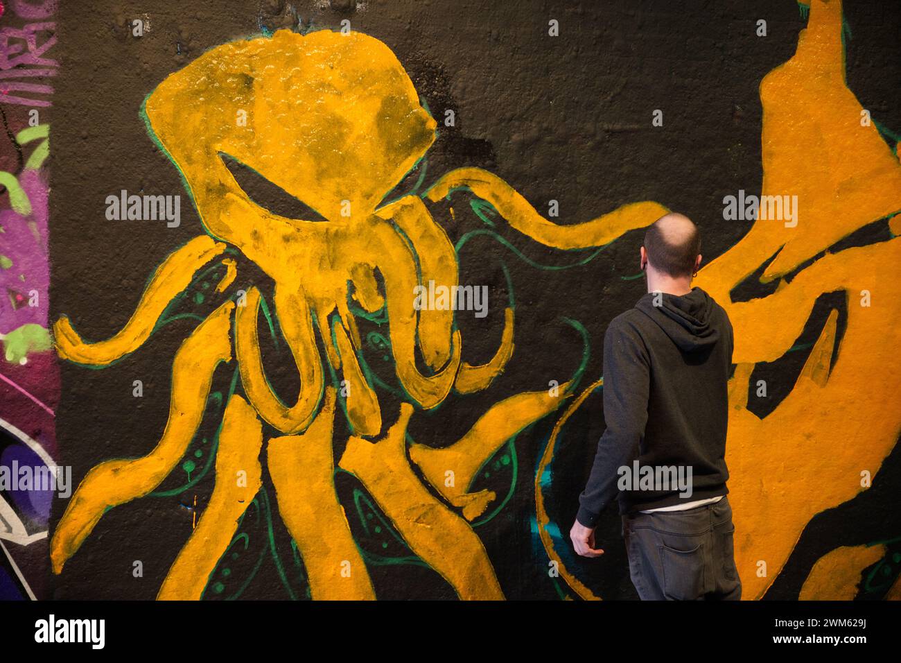 Un homme peignant des graffitis à Leake Street - Londres Banque D'Images