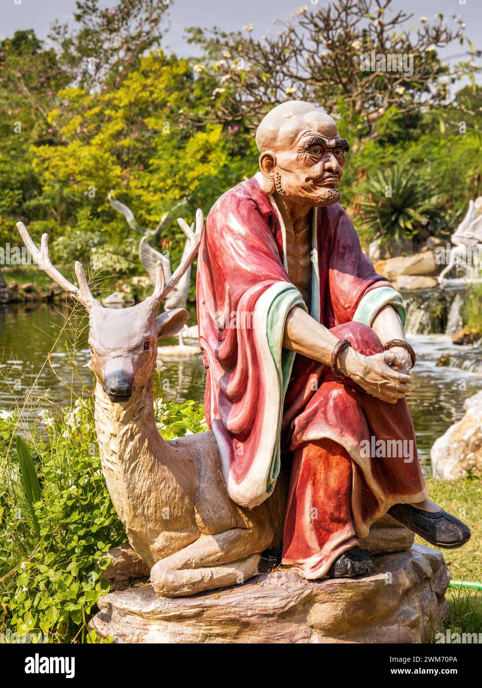 Moine avec statue de cerf à Ancient City, Bangkok, Thaïlande Banque D'Images