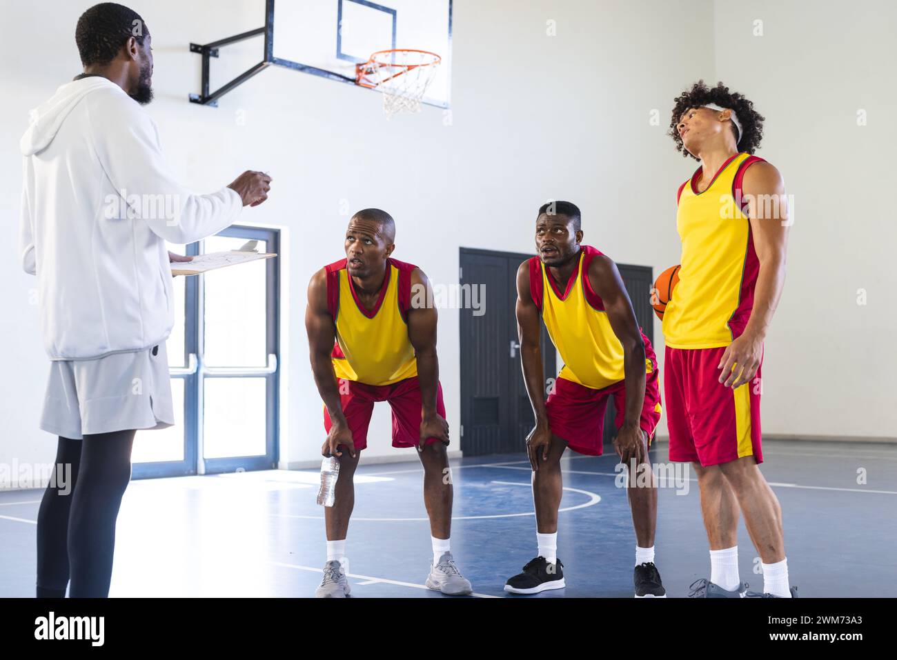 Entraîneur instruit les joueurs de basket-ball pendant l'entraînement Banque D'Images