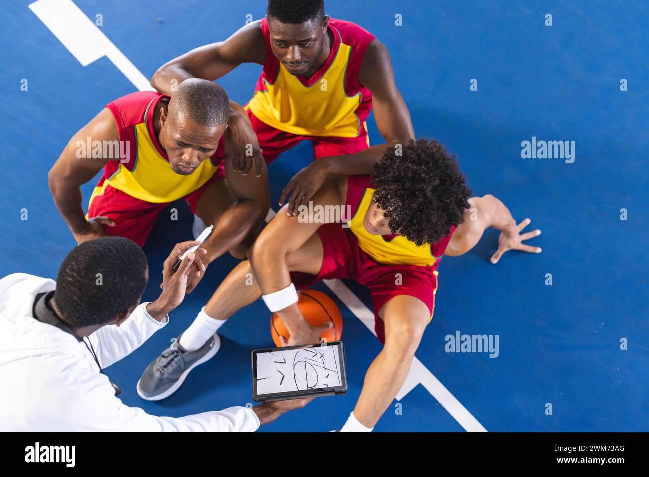 Une équipe de basket-ball diversifiée élabore des stratégies pendant une période d'inactivité Banque D'Images