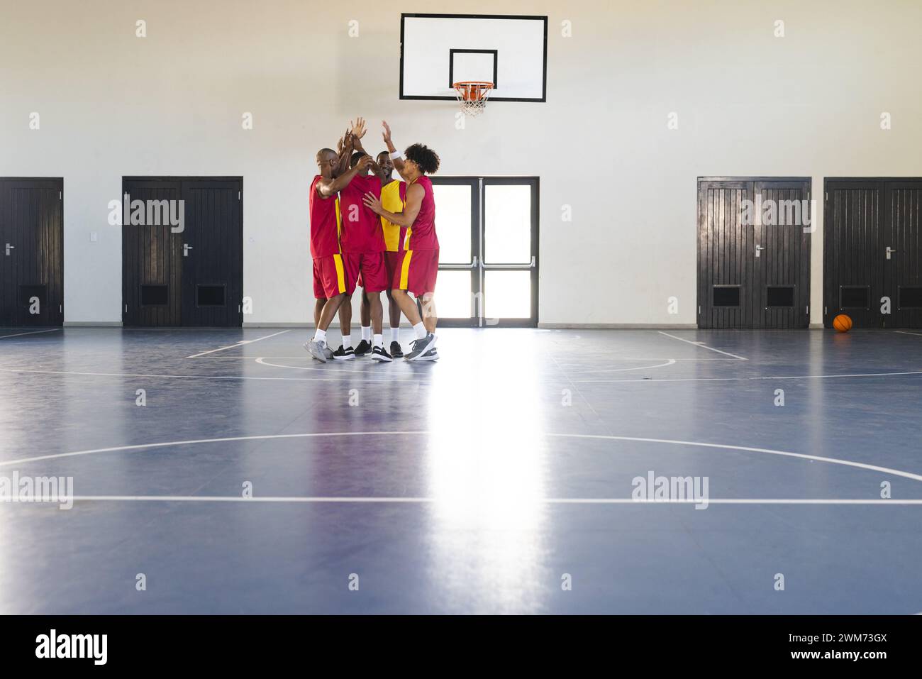 Les hommes afro-américains célèbrent une victoire au basket-ball dans un gymnase, avec espace de copie Banque D'Images