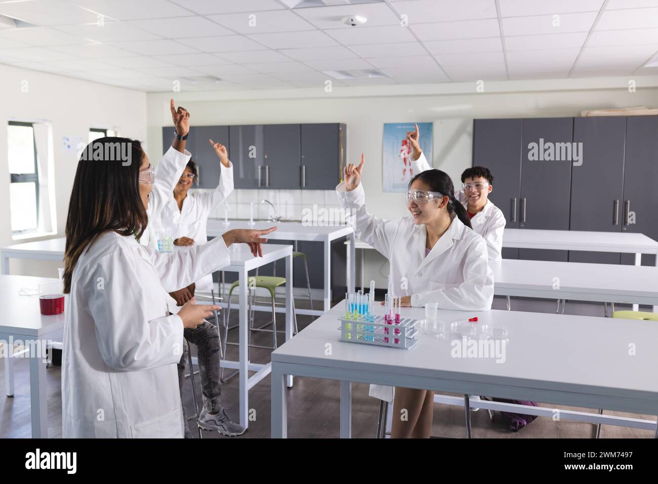 Divers étudiants s'engagent dans une expérience scientifique à l'école secondaire Banque D'Images