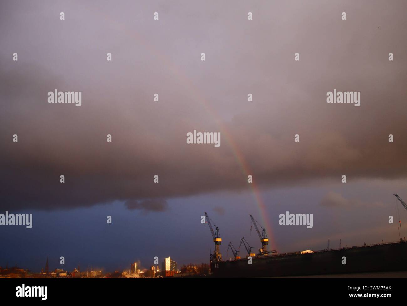 über den Hamburger Hafen zieht eine große und dunkle Wolkenbank. Kurz zeigt sich ein Regenbogen. *** Une grande banque de nuages sombre passe au-dessus du port de Hambourg Un arc-en-ciel apparaît brièvement Banque D'Images