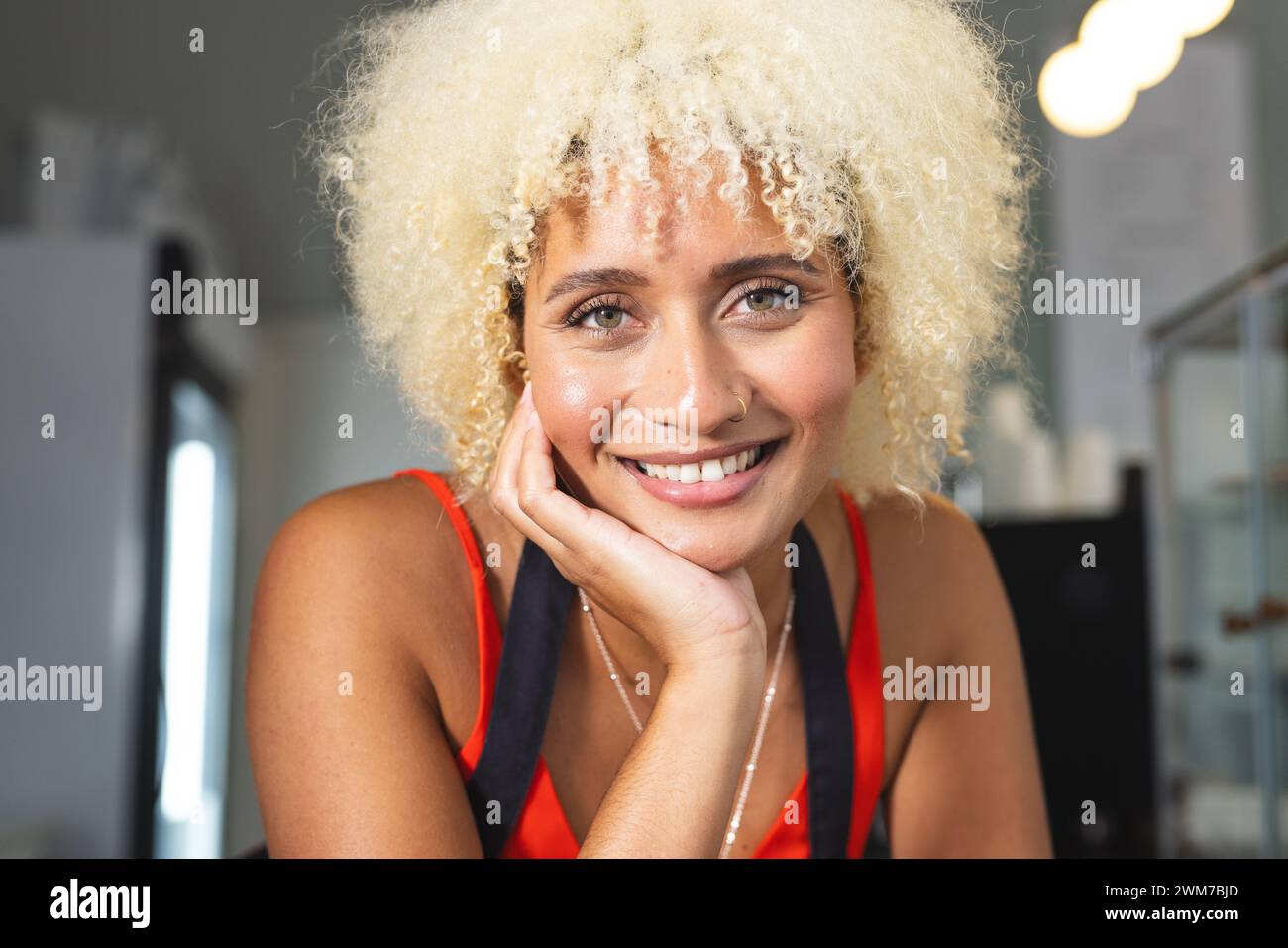 Une jeune femme biraciale propriétaire de café barista sourit chaleureusement à la caméra Banque D'Images