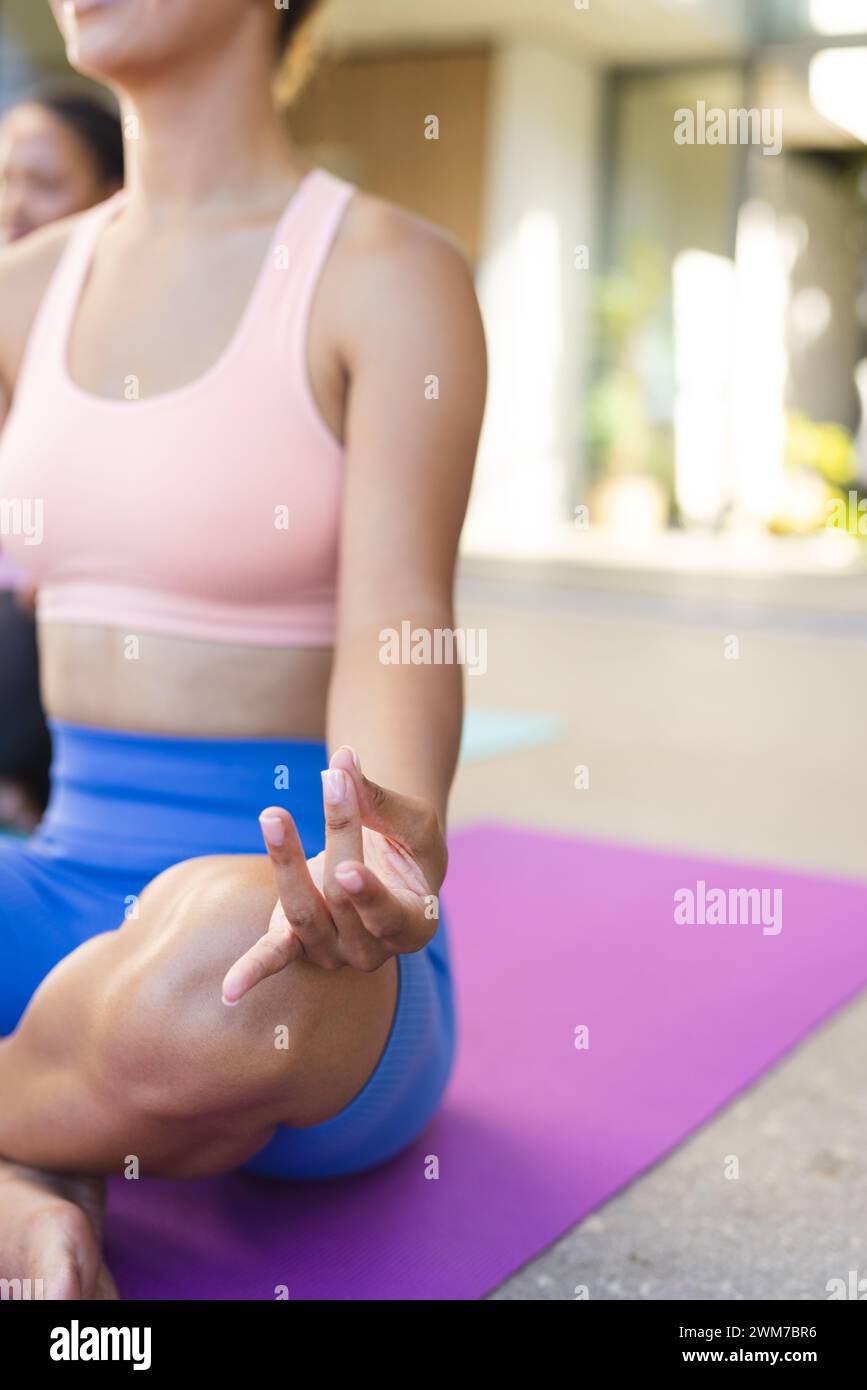 Jeune femme biraciale pratique le yoga en plein air, avec espace de copie Banque D'Images