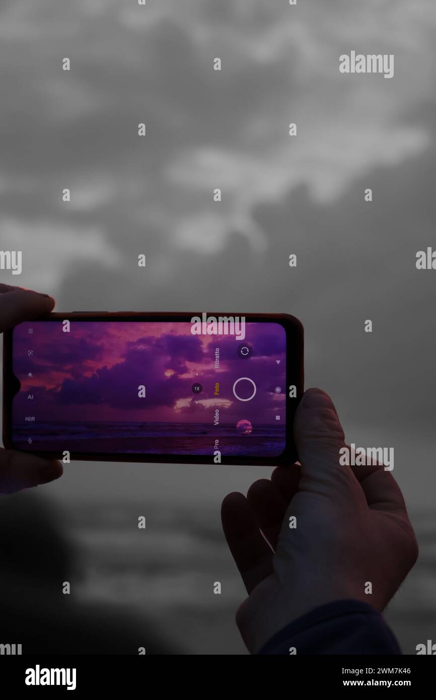 telefono che fotografa il tramonto, un homme prenant une photo du coucher du soleil, avec le mauvais temps, papier peint coucher de soleil Banque D'Images