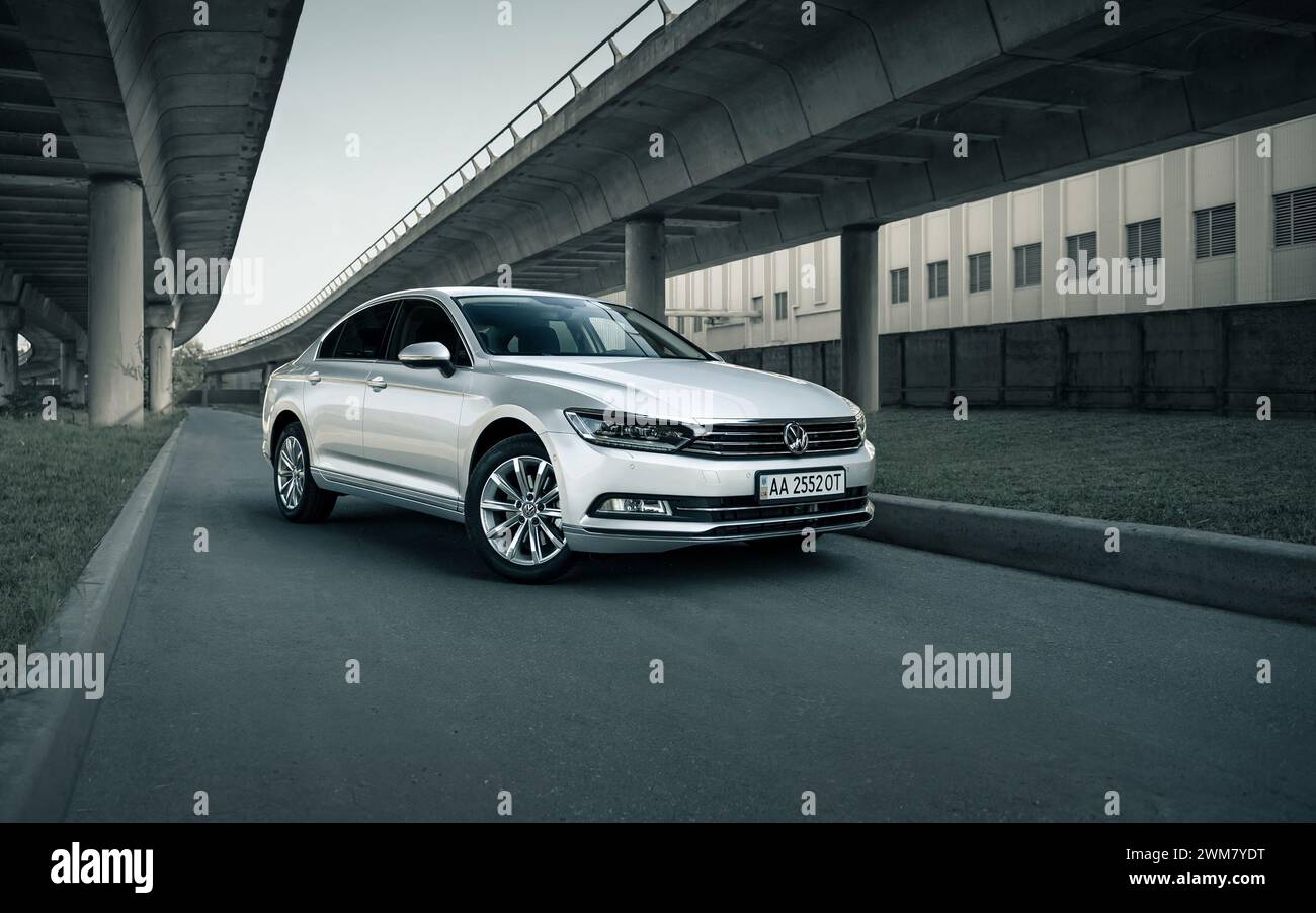 Volkswagen Passat argent sous deux ponts. Perspective vue de trois quarts avant de la berline allemande en milieu urbain. Banque D'Images