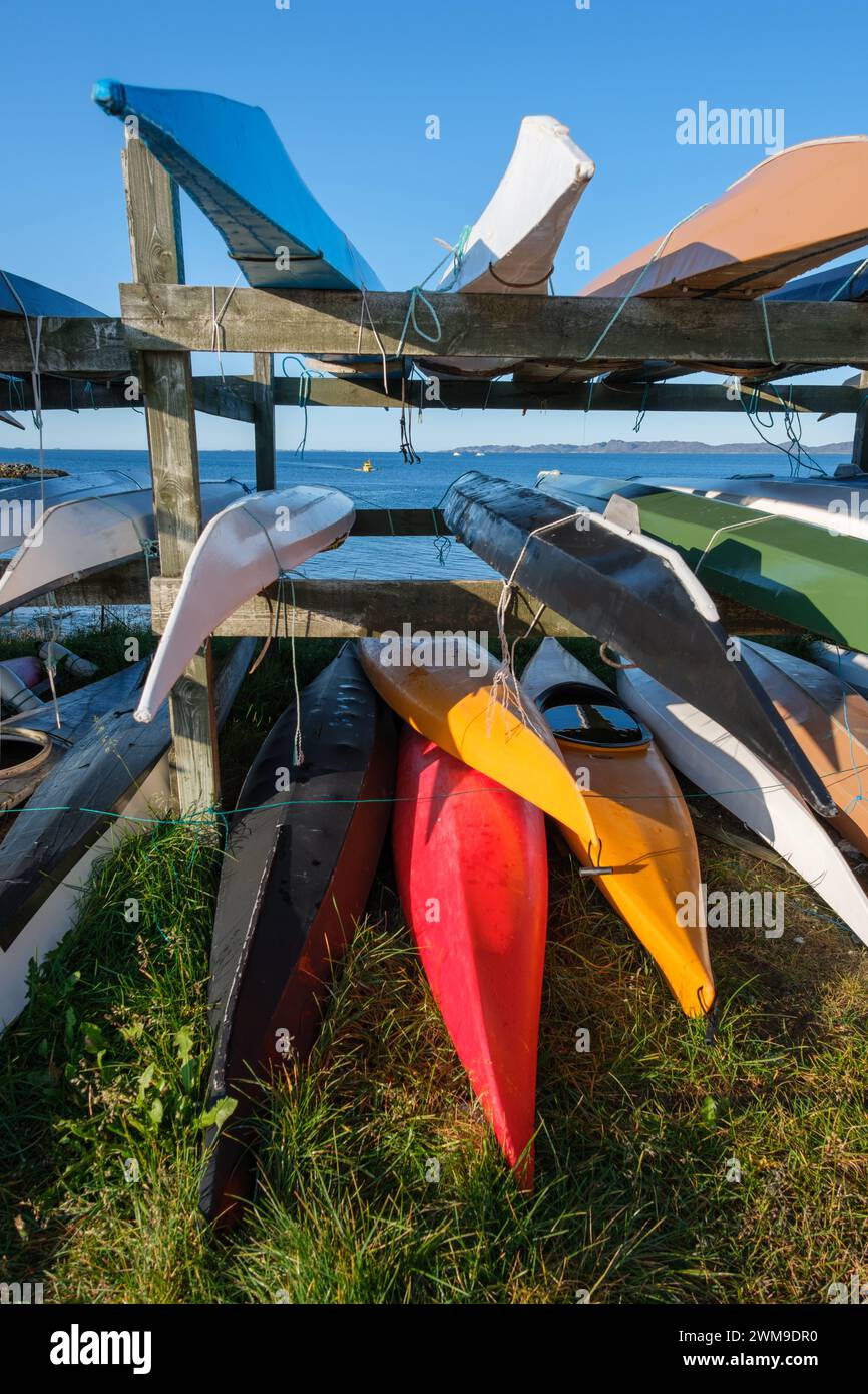 Longs et minces kayaks de style inuit empilés et prêts à partir au bord de la mer. Nuuk, Groenland Banque D'Images