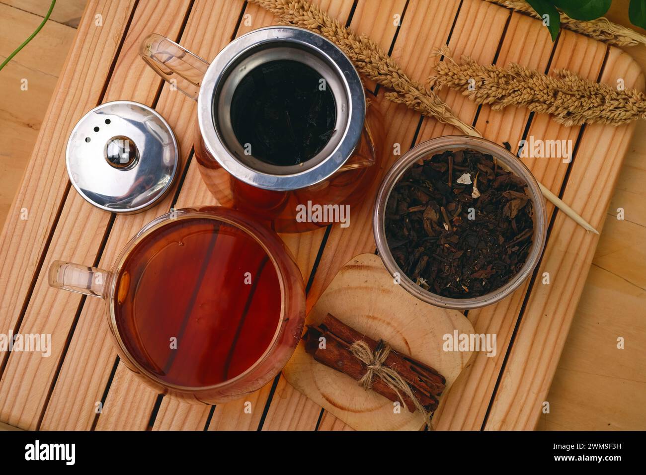 Boisson chaude à base de tisane dans une composition en verre avec de la cannelle sur une palette en bois Banque D'Images