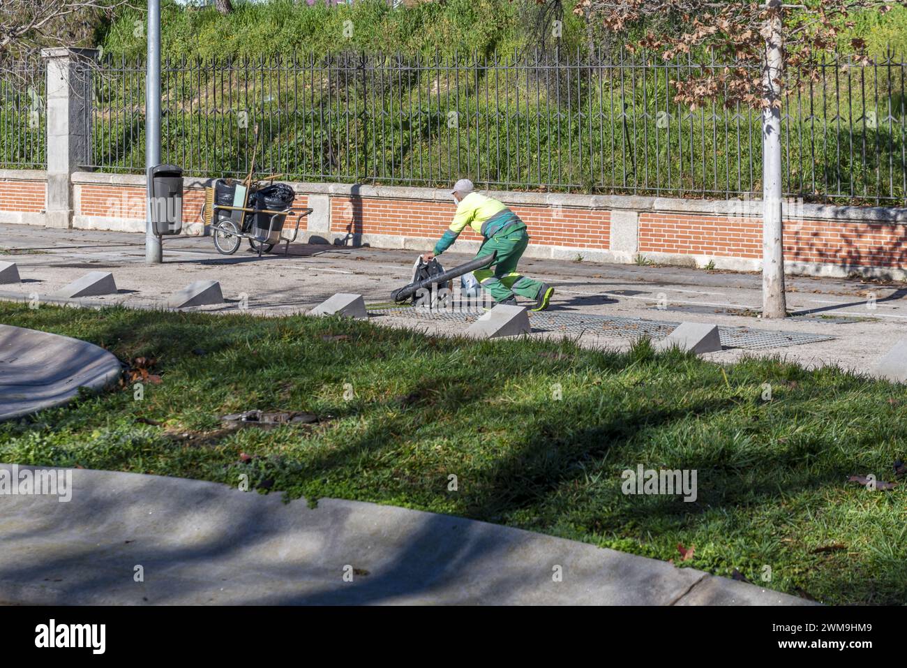 Un employé municipal de nettoyage urbain des rues préparant un canon à air pour enlever les feuilles Banque D'Images