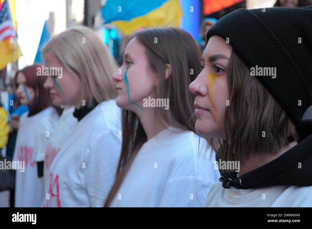 Des manifestants pro-Ukraine, portant chacun un t-shirt avec le nom d'une ville ukrainienne écrit dessus, se rassemblent à Times Square. Des manifestants se sont rassemblés à Manhattan, New York City, à l'occasion des deux ans de l'invasion russe de l'Ukraine. Les manifestants ont condamné l'invasion et se sont opposés au président russe Vladimir Poutine. Le week-end dernier, les forces russes ont capturé la ville ukrainienne orientale d'Avdiivka située sur la ligne de front. La perte de la ville survient alors qu'un paquet d'aide de 60 milliards de dollars pour l'Ukraine de la part des États-Unis a été bloqué à la suite de désaccords au Congrès. Président ukrainien, Volodymyr Zelen Banque D'Images