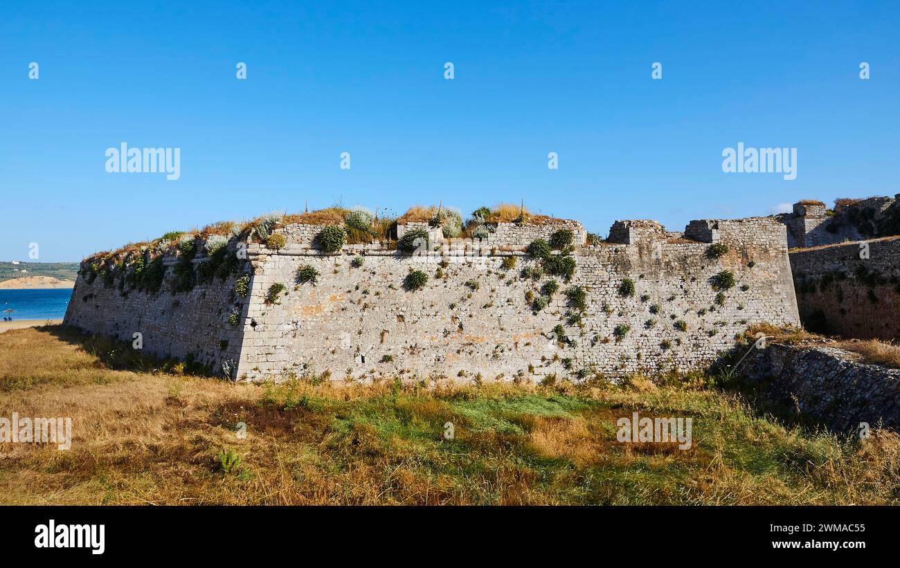 Partie des ruines d'une forteresse en pierre avec des zones herbeuses en face, forteresse maritime Methoni, Péloponnèse, Grèce Banque D'Images