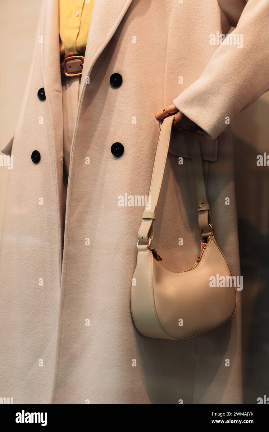 Détails de mode d'un long manteau beige et d'un petit sac à main. Vêtements et accessoires de mode décontractés pour femmes Banque D'Images
