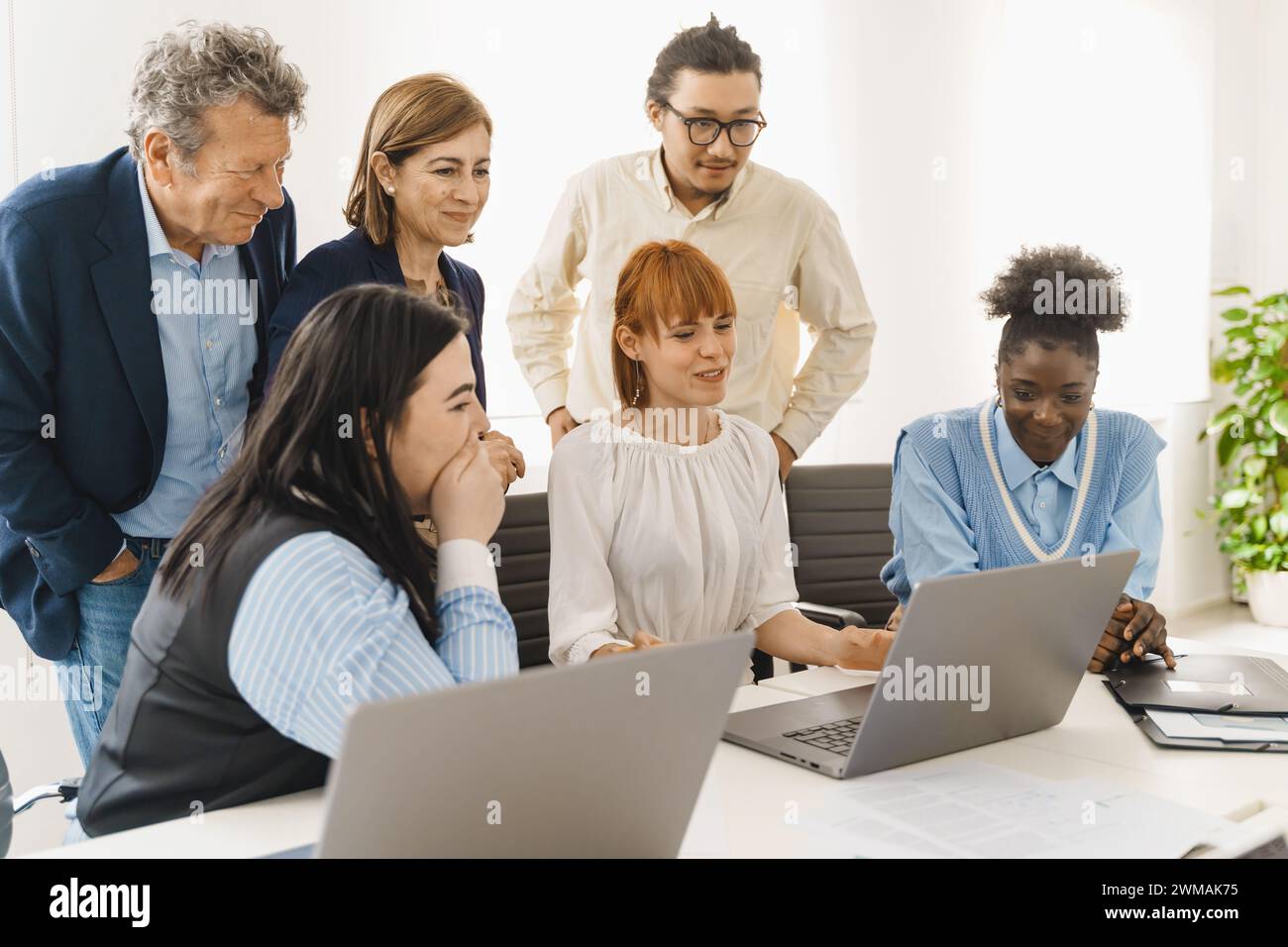 Équipe diversifiée évaluant un projet en ligne - employés engagés partageant des idées - analyse collaborative du travail numérique. Banque D'Images