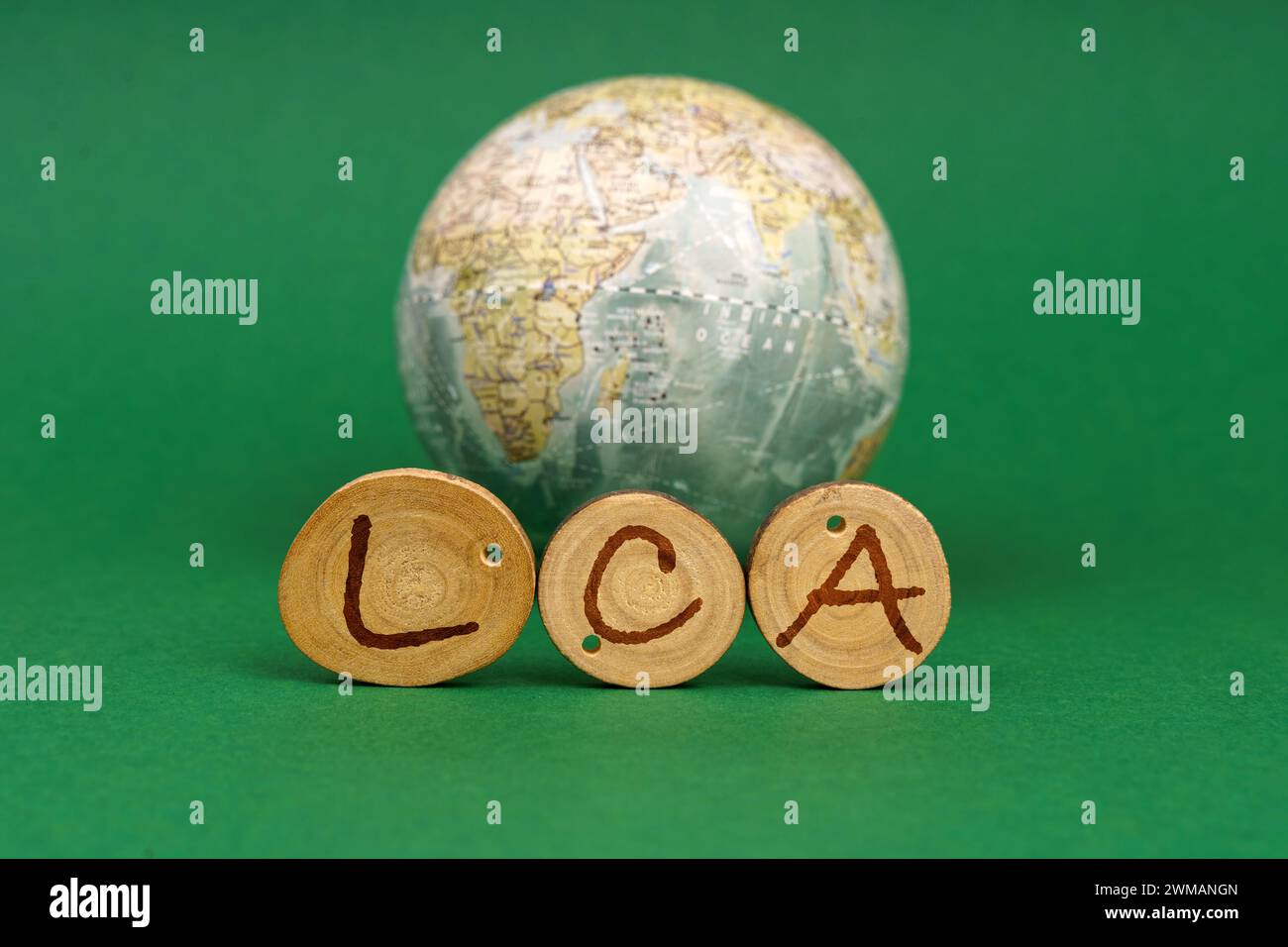 Concept écologique. Sur un fond vert il y a un globe terrestre et des ronds en bois avec l'inscription - LCA Banque D'Images