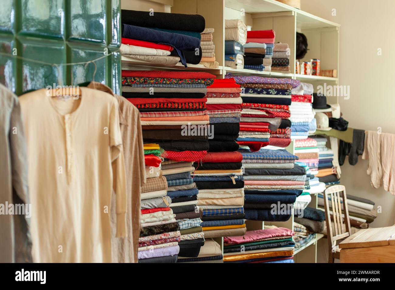 Tissus dans le magasin rétro. Magasin de vêtements et de tissus vintage. Une étagère complète de marchandises colorées. Banque D'Images