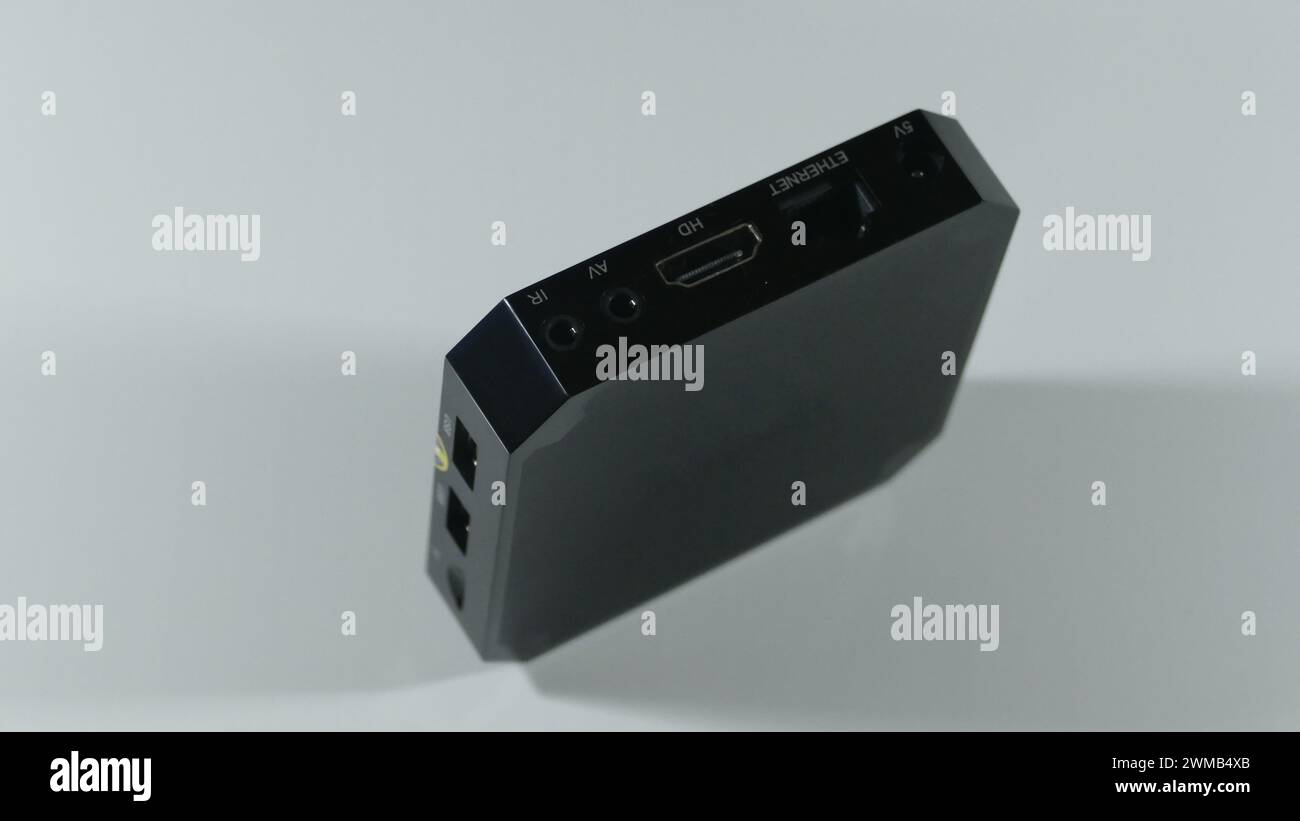 Un tuner TV noir carré se tient sur un bord avec des fentes et des prises visibles pour la connexion Banque D'Images