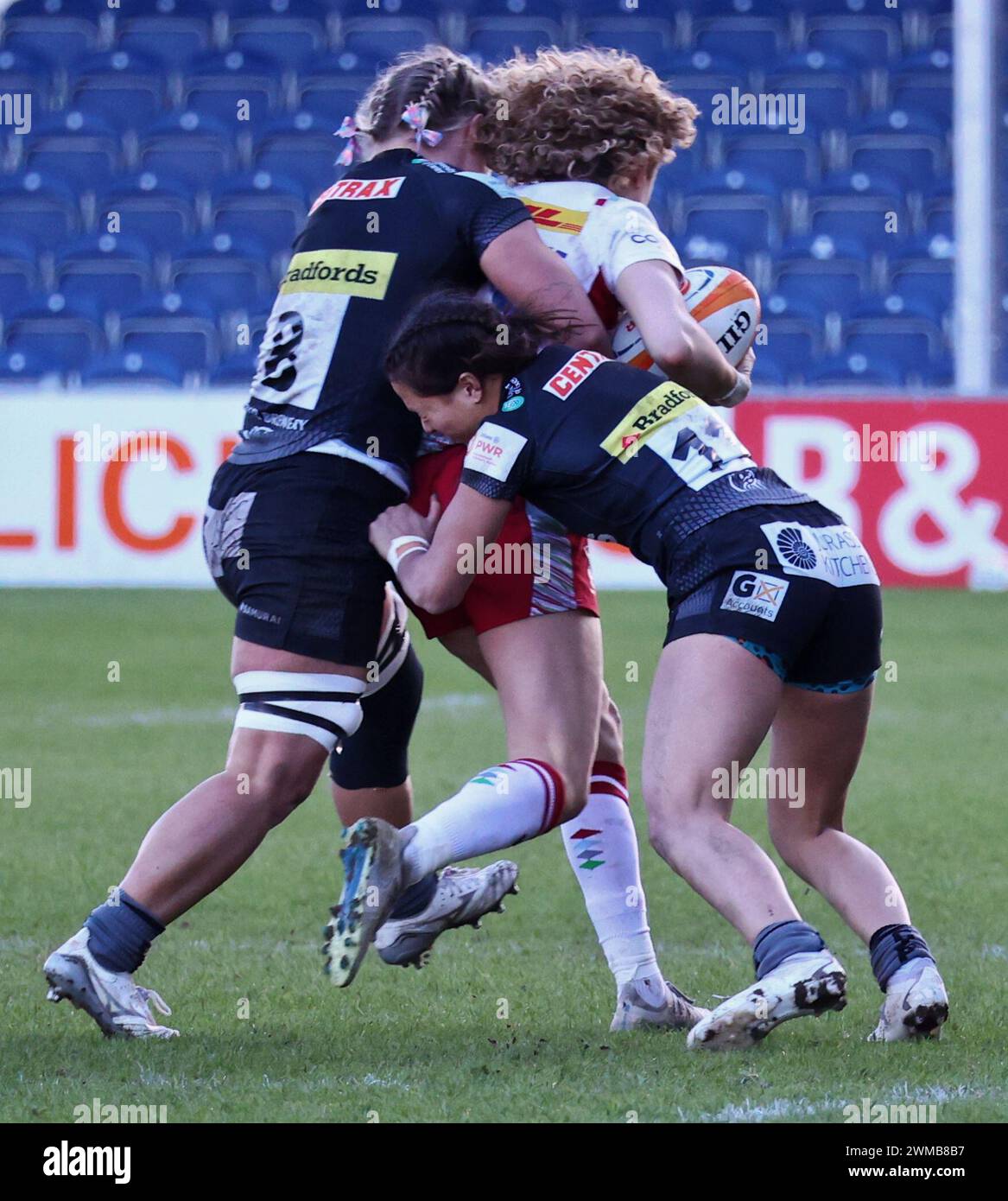Exeter, Devon, Royaume-Uni. 24 février 2024. Allianz Premiership Women's Rugby : Exeter Chiefs v Harlequins Women at Sandy Park, Exeter, Devon, Royaume-Uni. Photo : Ellie Kildunne attaquée par 2 joueurs de chefs crédit : Nidpor/Alamy Live News Banque D'Images